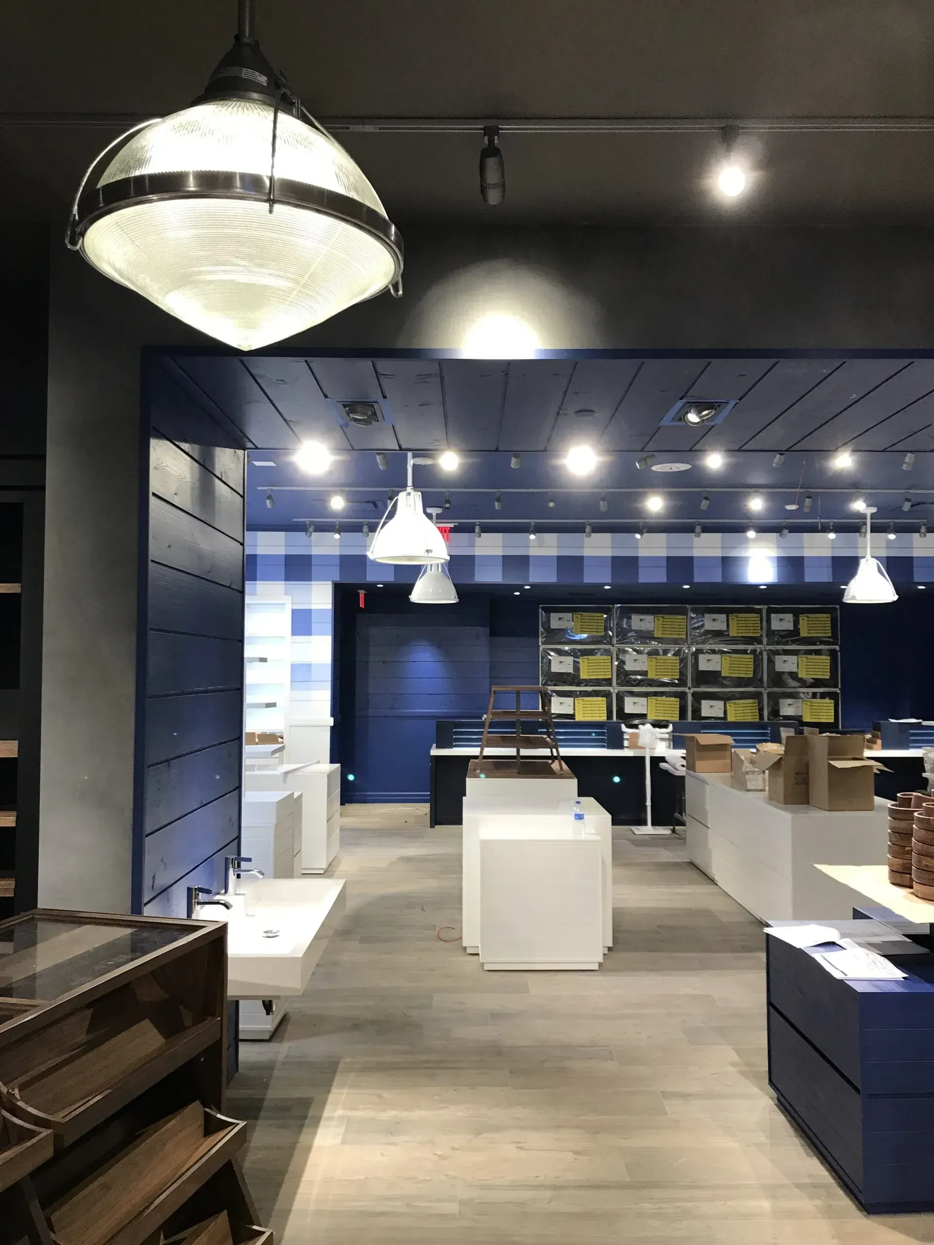 Interior of a Bath & Body Works store with blue and white accents, illuminated by pendant lights.